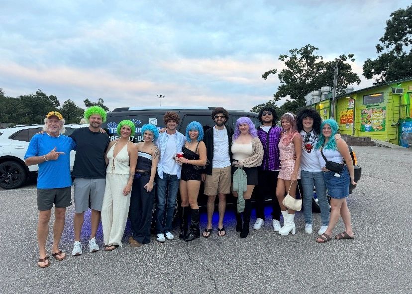 Bachelorette party group in colorful wigs celebrating outdoors